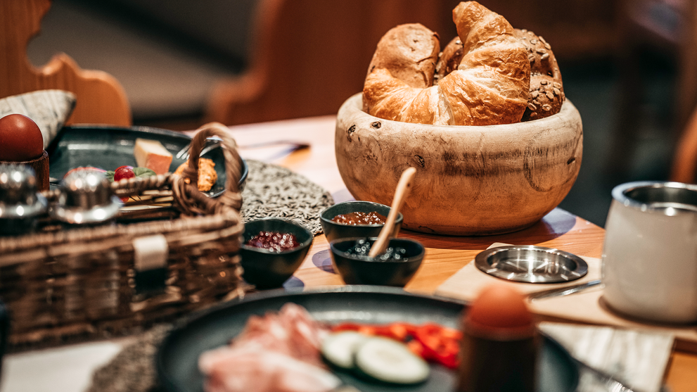 Frühstücksbuffet mit Gebäck, Obst und regionalen Spezialitäten.