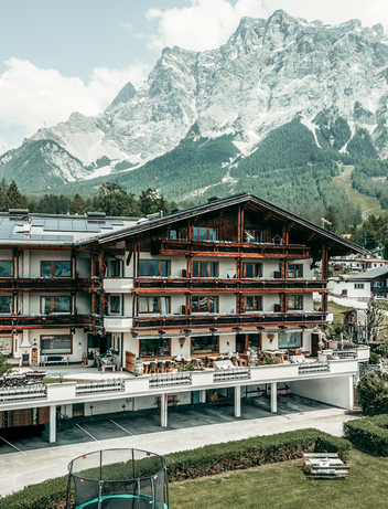 Hotelgebäude vor einer eindrucksvollen Bergkulisse.