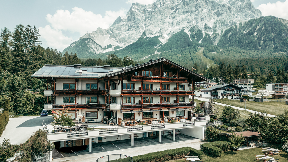 Hotelgebäude vor einer eindrucksvollen Bergkulisse.