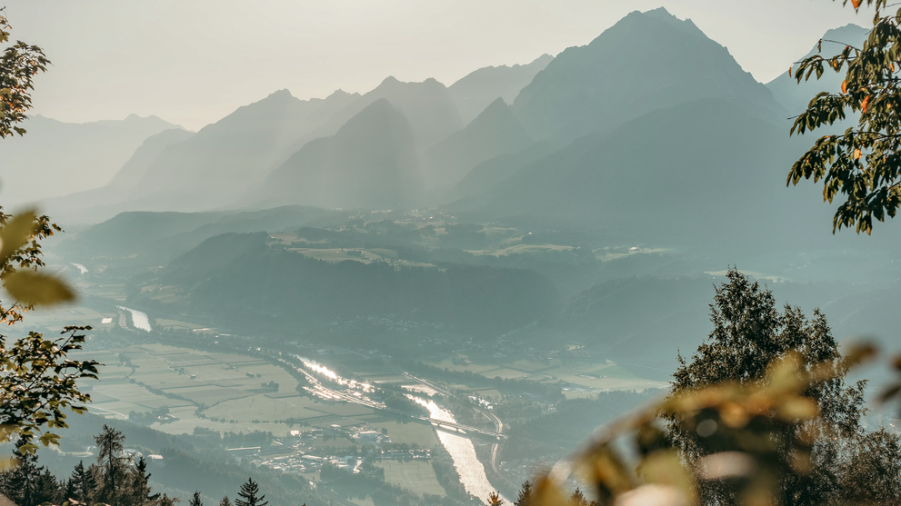 Blick auf eine Berglandschaft mit See und Tal im Hintergrund.