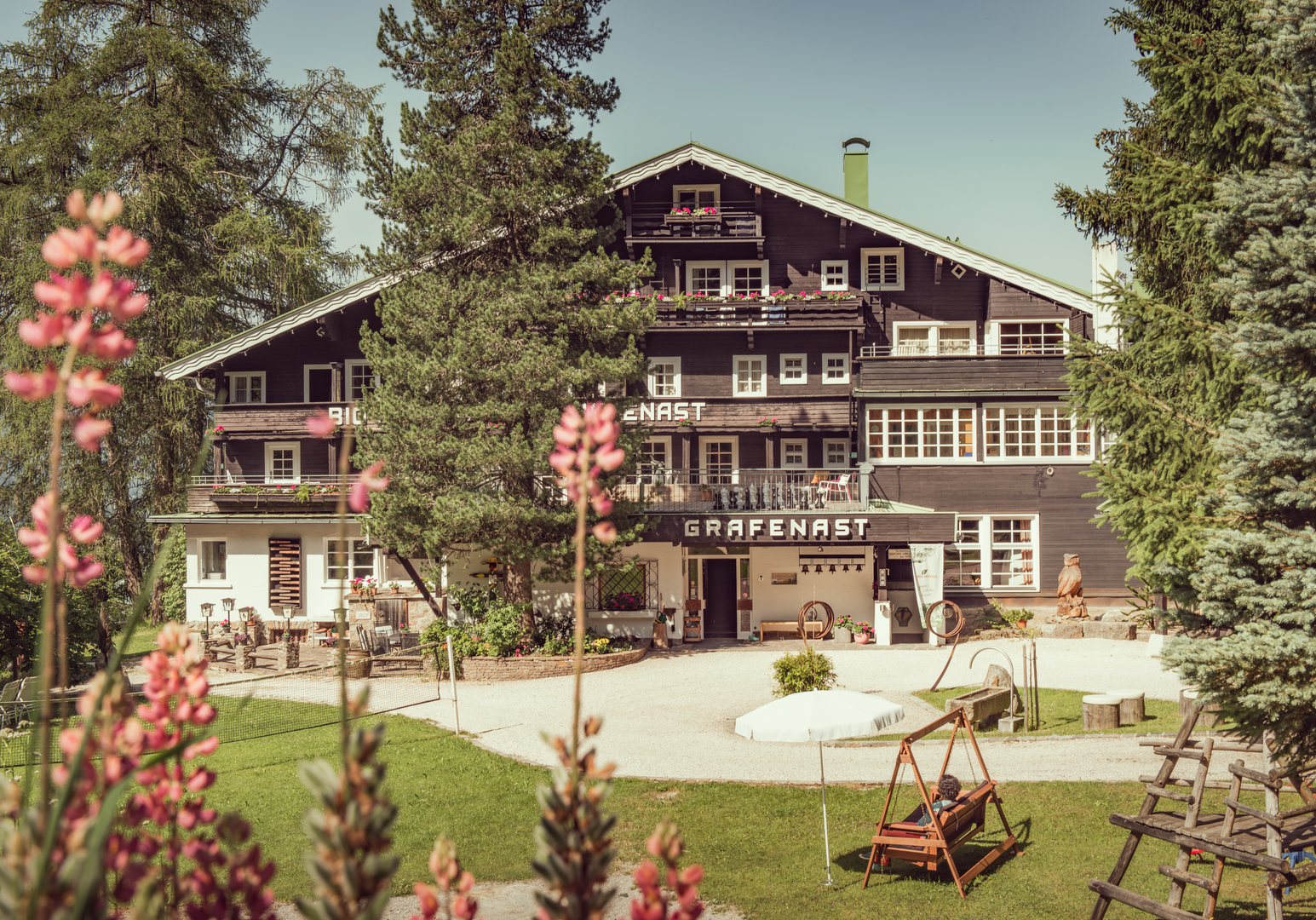 Hotelgebäude in naturnaher Berglage mit Gartenanlage.
