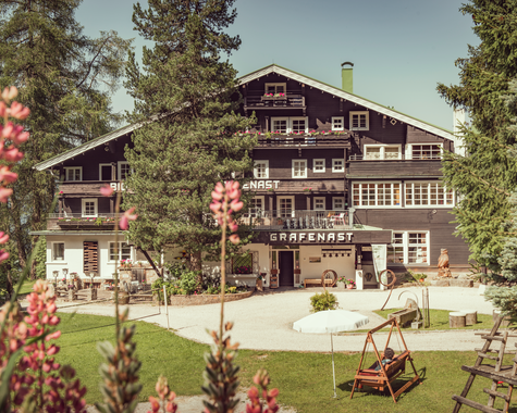 Hotelgebäude in naturnaher Berglage mit Gartenanlage.