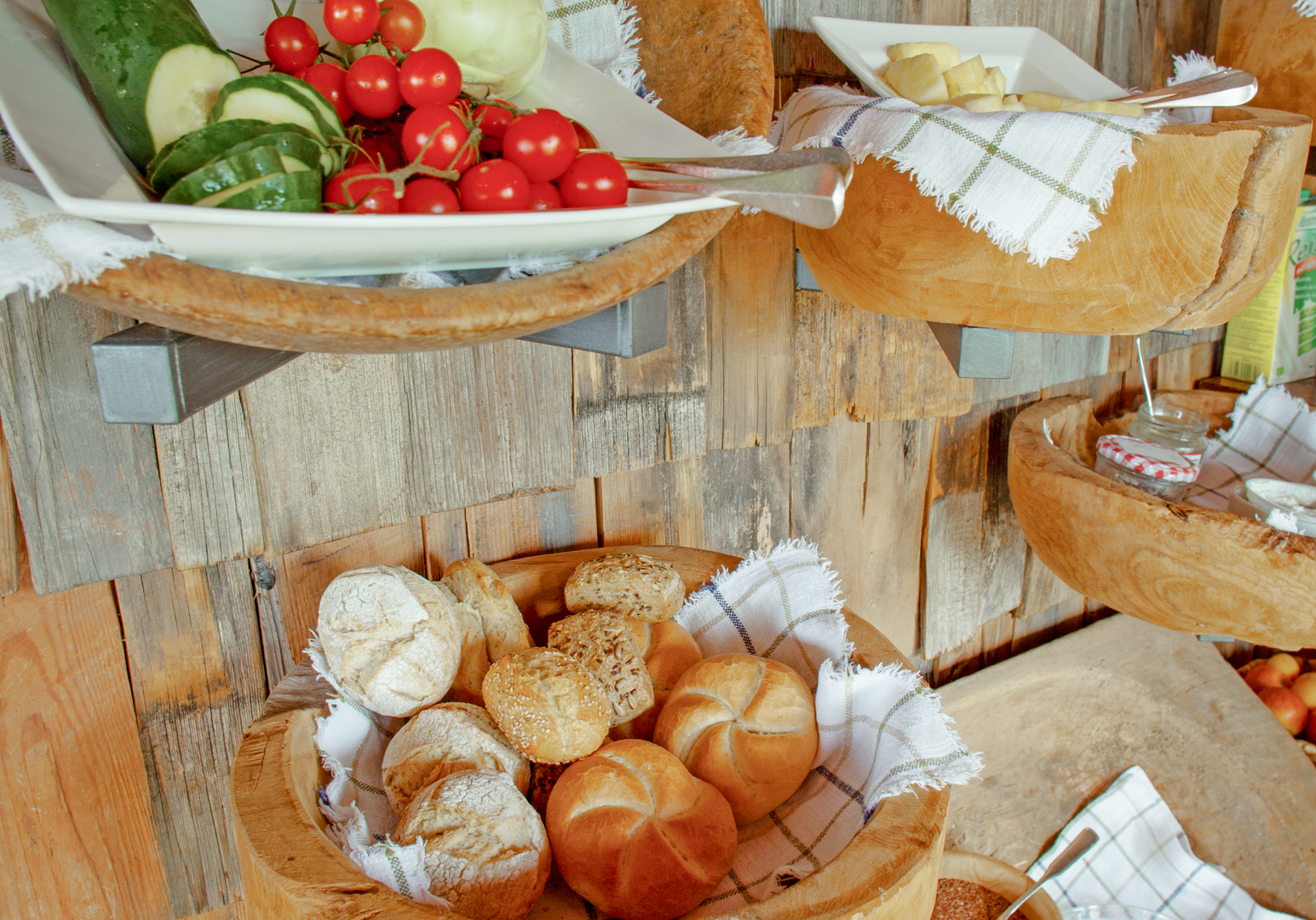 Frühstücksbuffet mit Brot, Obst und regionalen Spezialitäten.