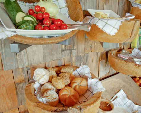 Frühstücksbuffet mit Brot, Obst und regionalen Spezialitäten.