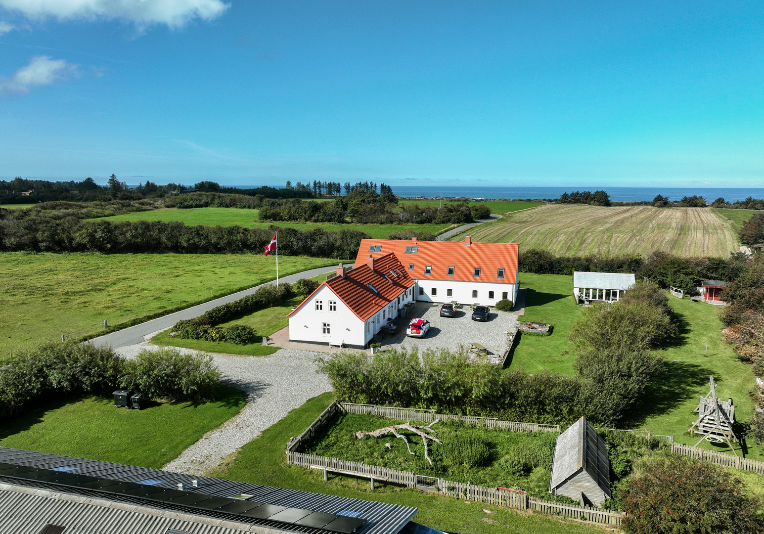 Luftbild eines landwirtschaftlichen Hofes mit Wohnhaus, Nebengebäuden und umliegenden Feldern