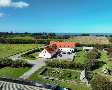 Luftbild eines landwirtschaftlichen Hofes mit Wohnhaus, Nebengebäuden und umliegenden Feldern