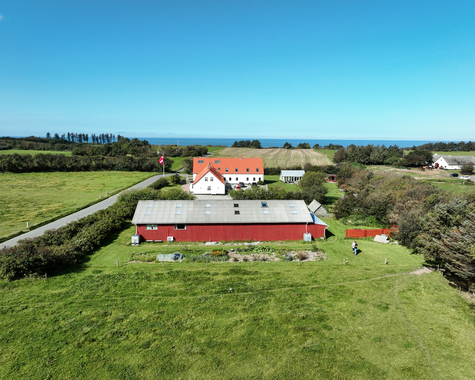 Hofgelände mit großem Gebäude und Scheune, umgeben von Wiesen und Hecken, aus der Vogelperspektive