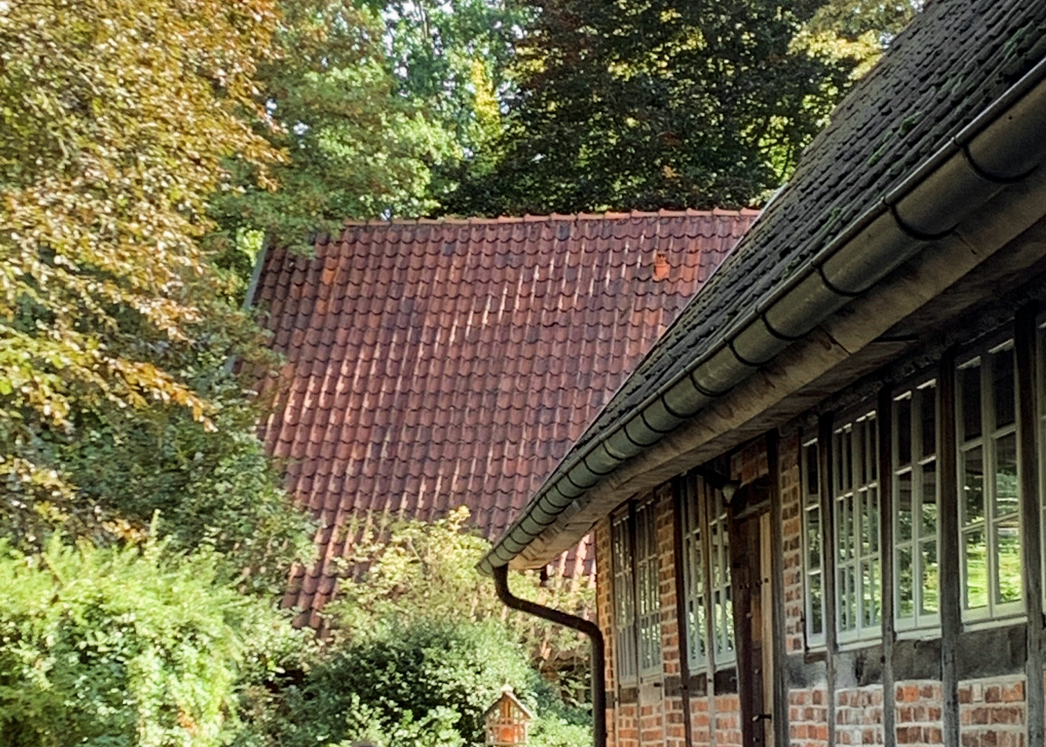 Idyllischer Innenhof mit Fachwerkgebäude, Bäumen und einem laufenden Kind 