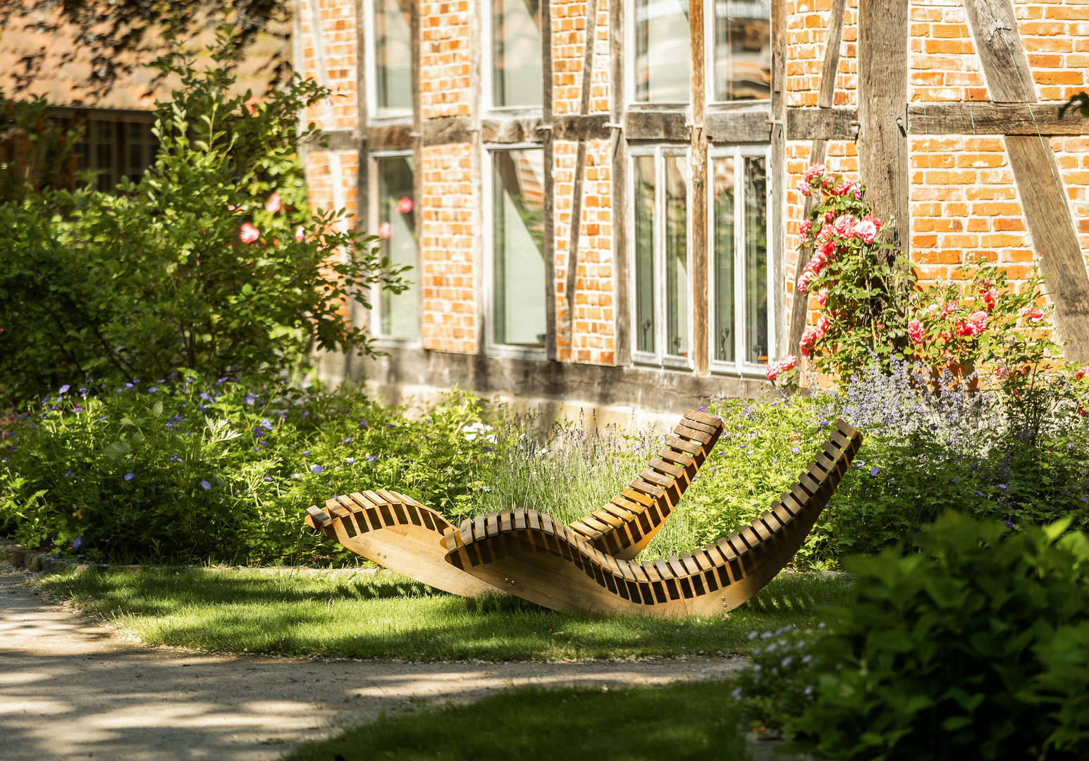 Gemütlicher Garten mit Liegestühlen vor einer Hauswand