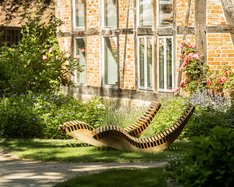 Gemütlicher Garten mit Liegestühlen vor einer Hauswand