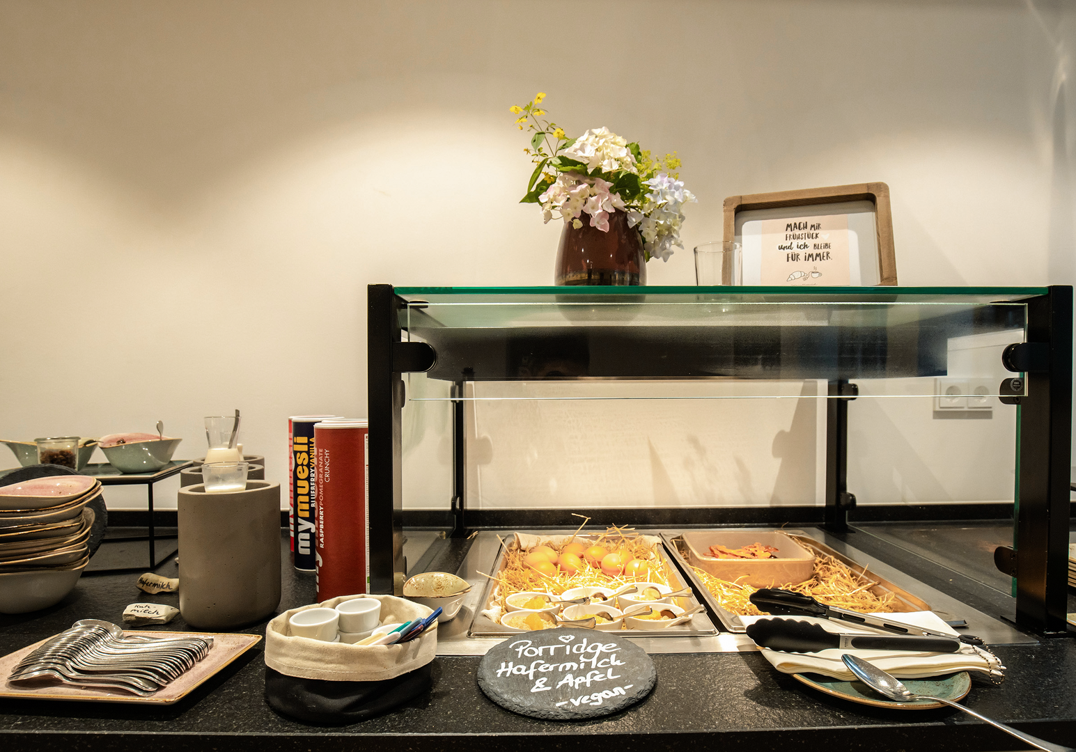 Frühstücksbuffet mit Geschirr, Brot und Blumen 