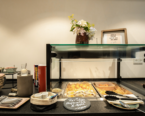 Frühstücksbuffet mit Geschirr, Brot und Blumen 