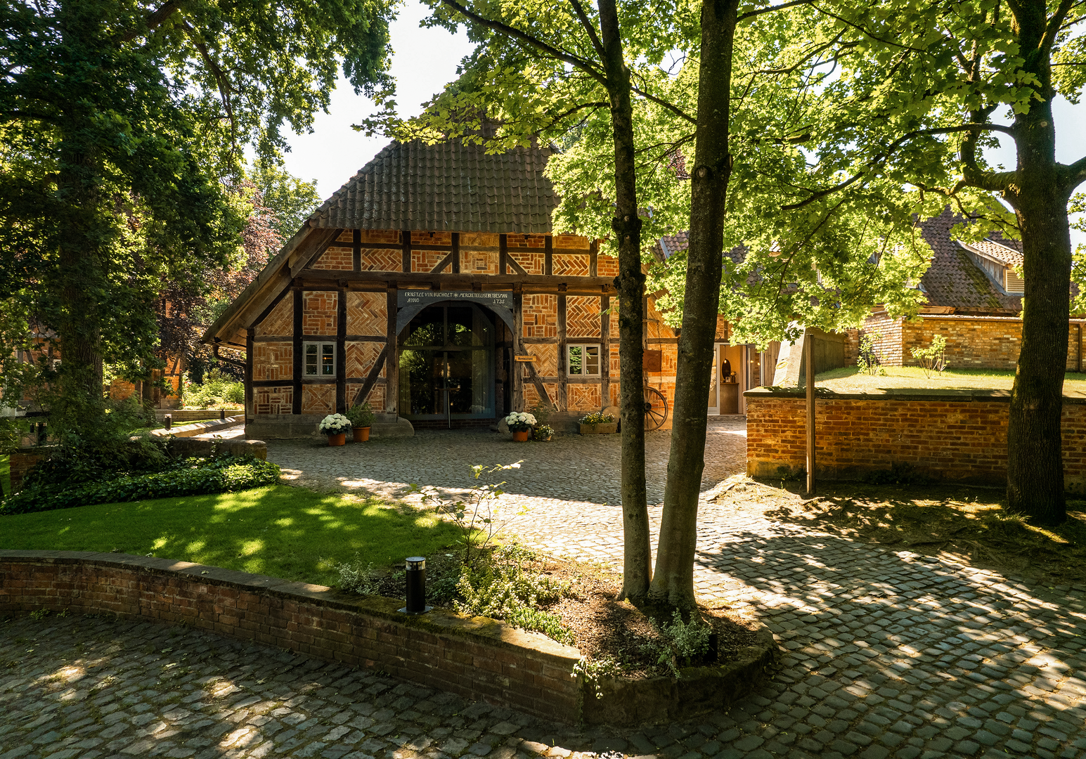 Fachwerkhaus zwischen Bäumen mit schattigem Garten