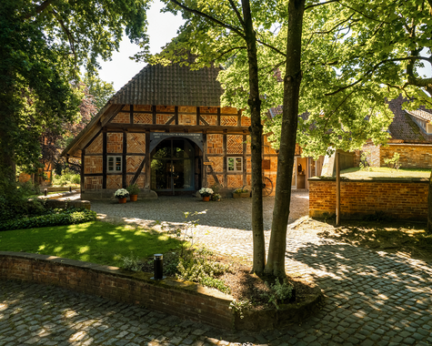 Fachwerkhaus zwischen Bäumen mit schattigem Garten