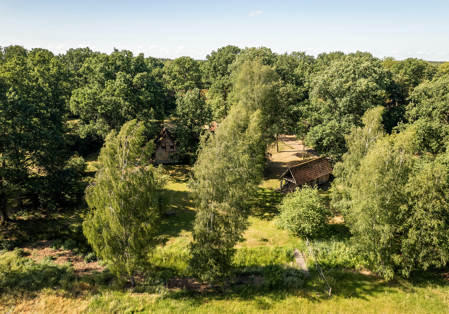 Landschaft mit Wiesen, Bäumen und einzelnen Gebäuden in ruhiger Umgebung