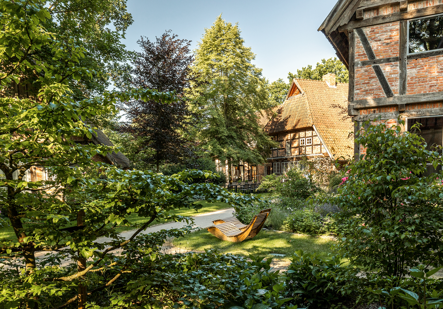 Üppiger Garten mit Liegestühlen und Fachwerkhaus im Hintergrund