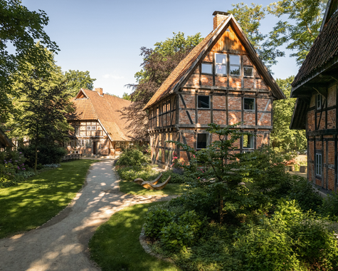 Historische Fachwerkhäuser entlang eines Weges im Grünen