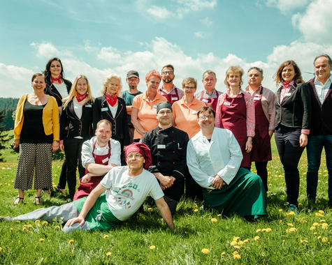 Gruppe von Erwachsenen steht gemeinsam auf einer Wiese