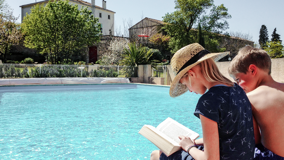 Kinder lesen am Poolrand 