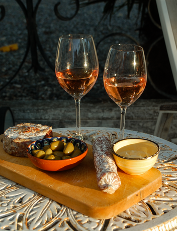 Nahaufnahme von Wein, Getränken und Snacks auf einem Tisch im Freien