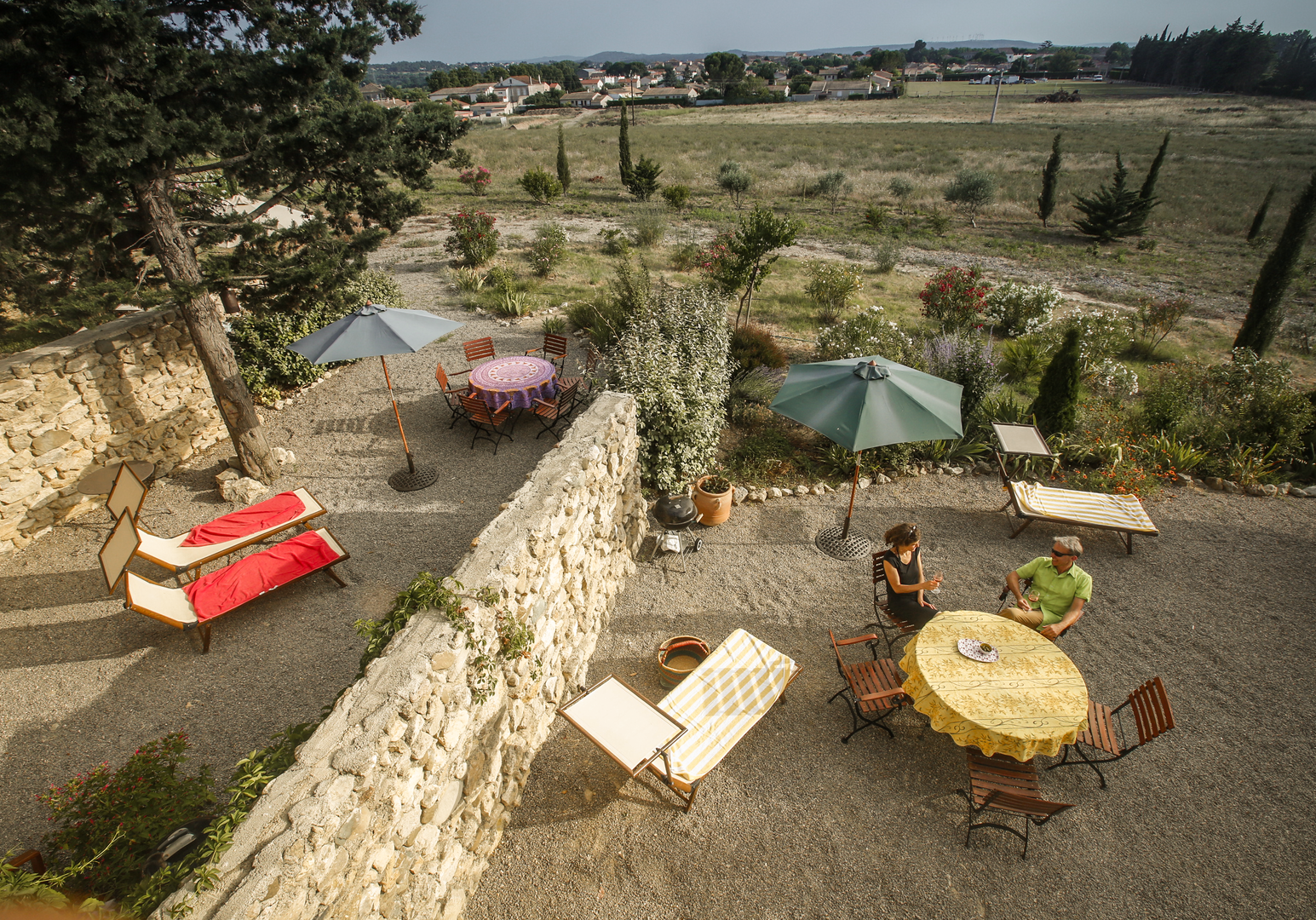 Terrasse von oben mit Tisch und Liegestühlen 