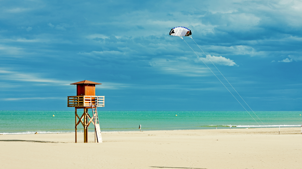Sandstrand mit Rettungsturm und Blick auf das weite Meer