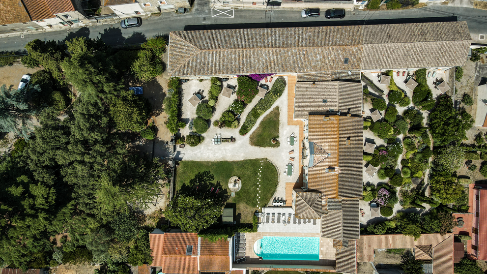 Luftaufnahme einer Ferienanlage mit Garten, Pool und Gebäuden