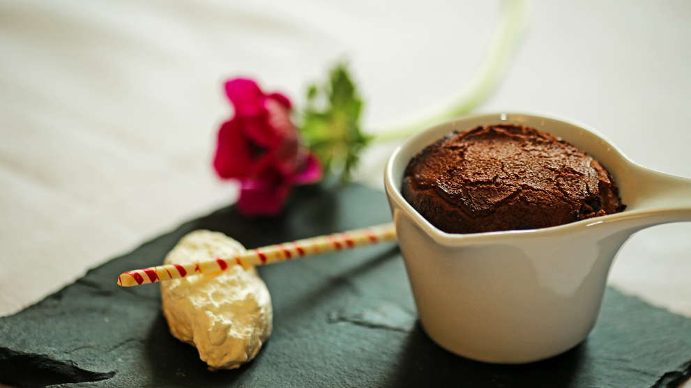 Dessert mit Schokoladenmousse und kleinem Gebäckstück auf einem Teller angerichtet