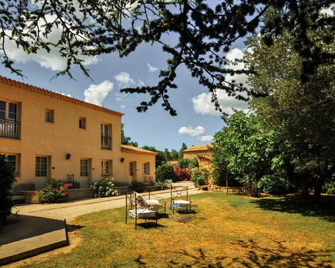 Landhaus mit Garten und Sitzmöglichkeiten im Schatten von Bäumen