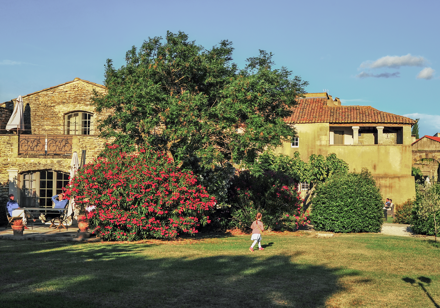 Ferienanlage mit Garten, Bäumen und Gebäuden im Hintergrund