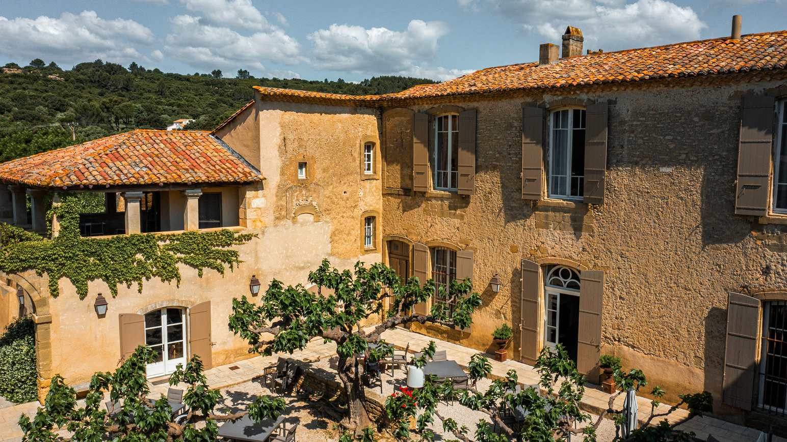 Innenhof eines mediterranen Landhauses mit Tischen und Pflanzen