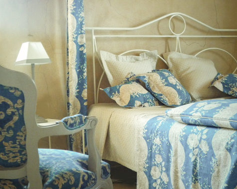 Himmelbett mit blauer Bettwäsche und antiken Möbeln