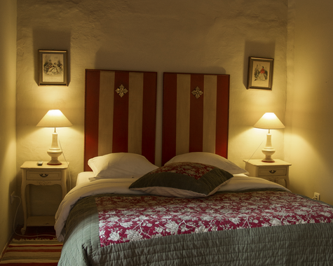 Doppelbett mit Holzkopfteil, grauer Decke und Teppich