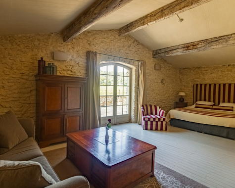 Helles Zimmer mit Doppelbett, Holztruhe und Steinwand
