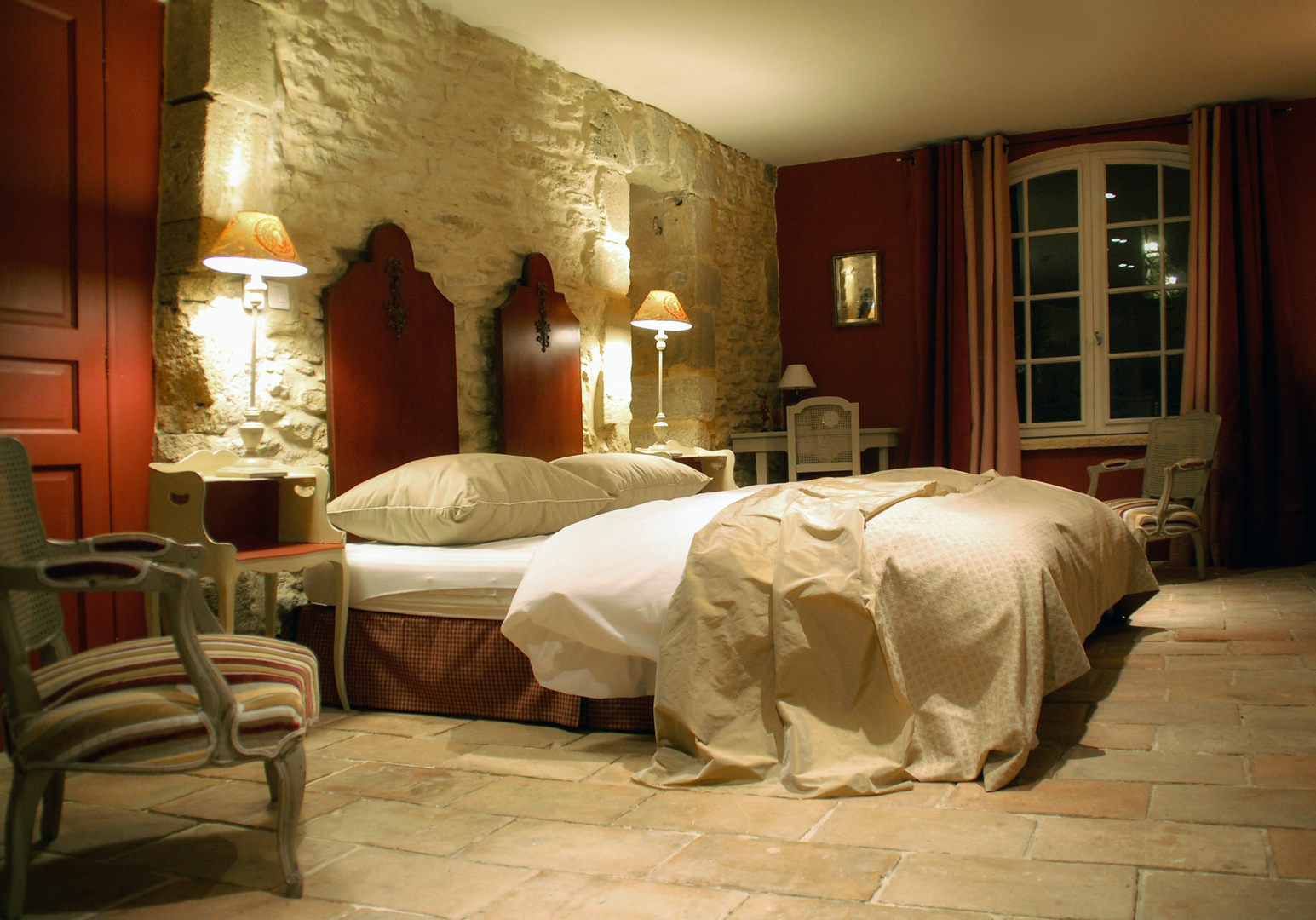 Schlafzimmer mit zwei Einzelbetten, Steinwand und antiken Möbeln