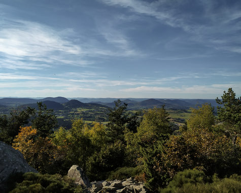 Aussicht über bewaldete Hügel und Täler bei wechselhaftem Himmel