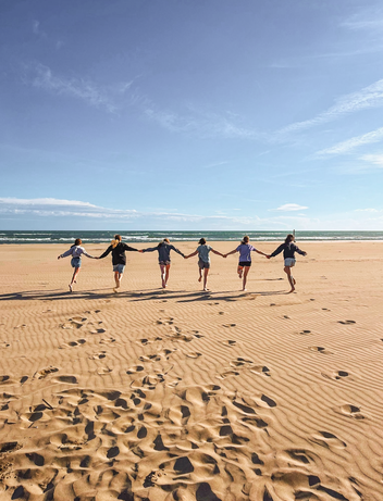 Kinder laufen und springen am Strand über den Sand