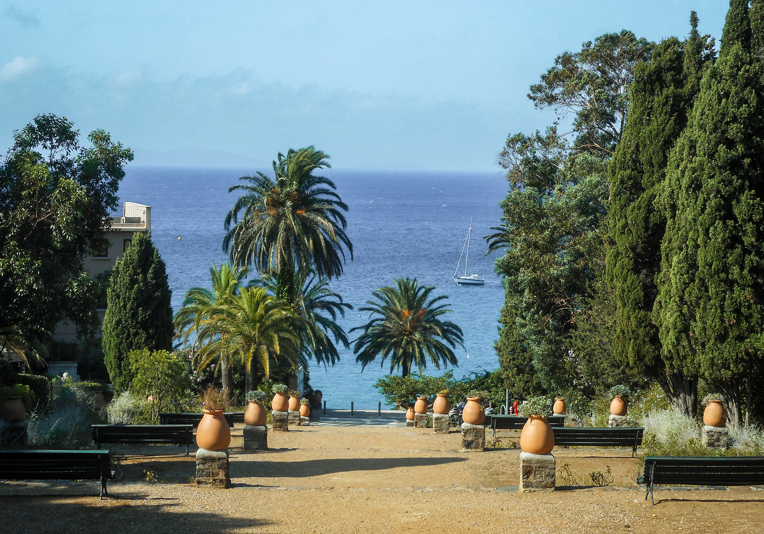Mediterraner Gartenweg mit Palmen und Blick aufs Meer