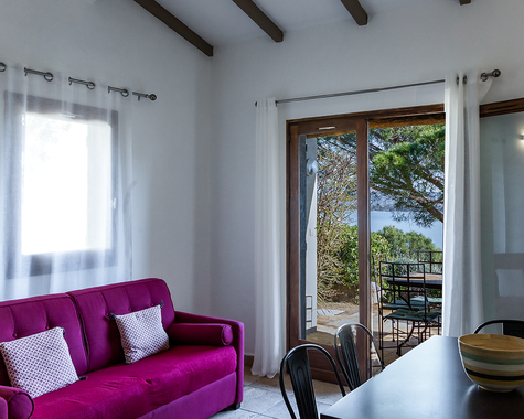 Wohnzimmer mit lila Sofa, Fenster und Terrassentür