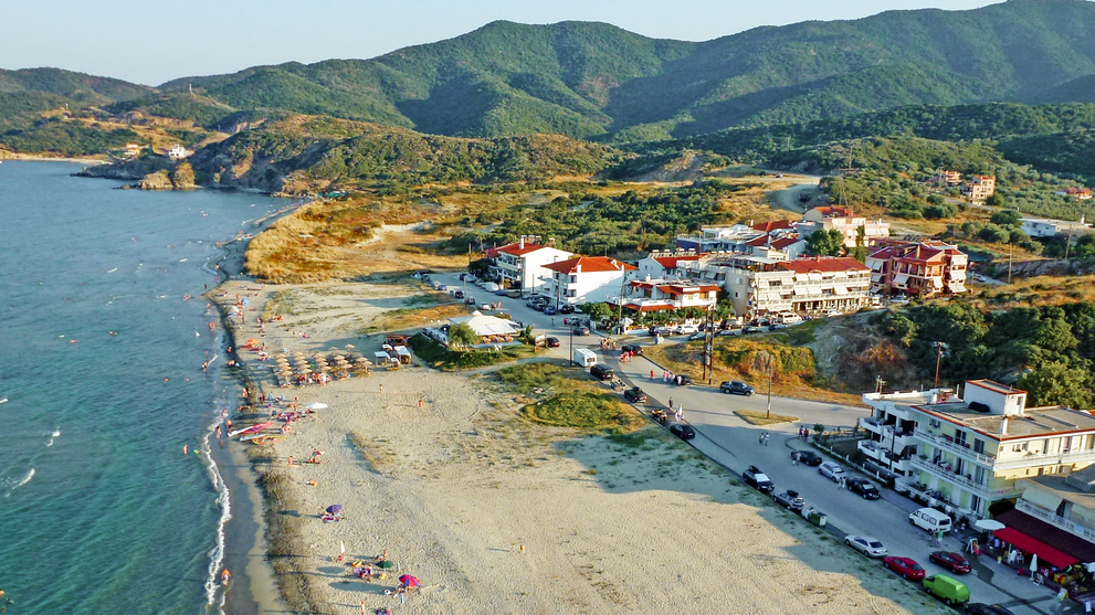 Luftaufnahme eines Küstenortes mit Strand und Berglandschaft