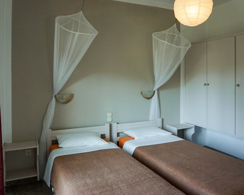 Schlafzimmer mit Einzelbetten und Moskitonetz