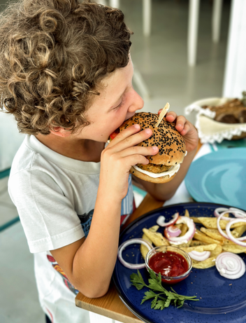 Kind genießt einen Burger mit Pommes 