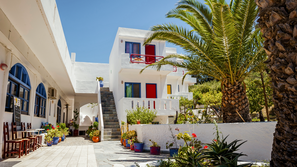 Weißes Ferienhaus mit Palmen und gepflegtem Innenhof