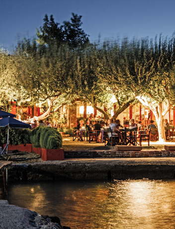 Beleuchtetes Restaurant am Wasser bei stimmungsvoller Abendatmosphäre