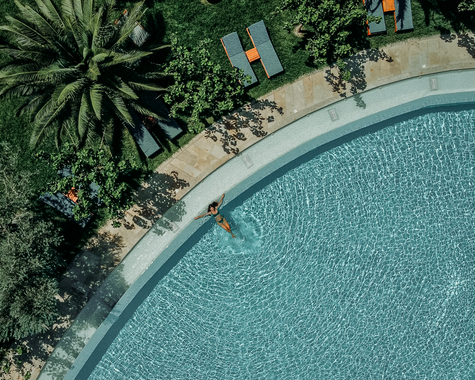 Luftaufnahme eines geschwungenen Pools mit Liegebereich