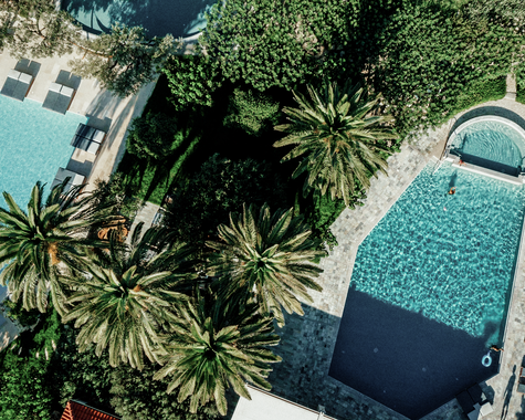 Luftaufnahme von Poollandschaft mit Palmen und Liegeflächen