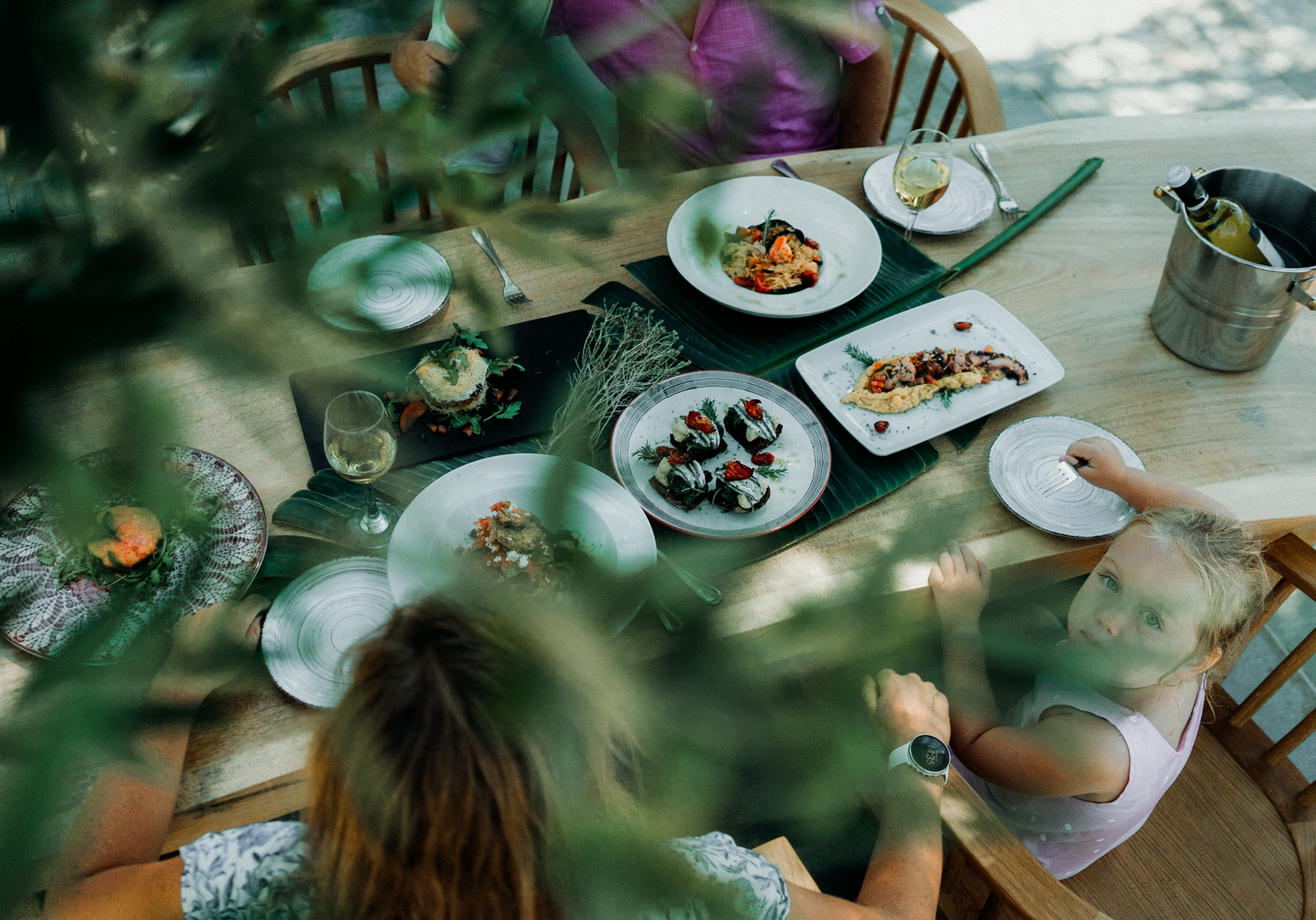 Frühstückstisch mit frischen Speisen im Grünen unter Bäumen