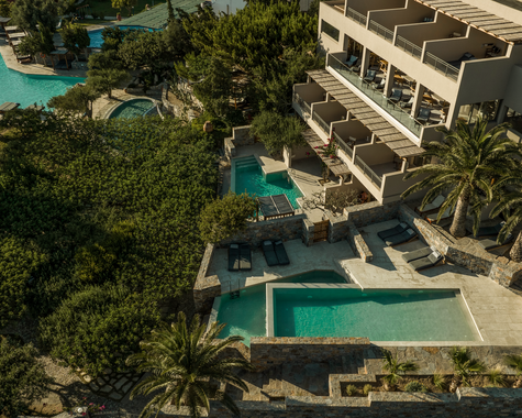 Luftaufnahme einer modernen Ferienanlage mit Pool und mediterraner Gartenlandschaft