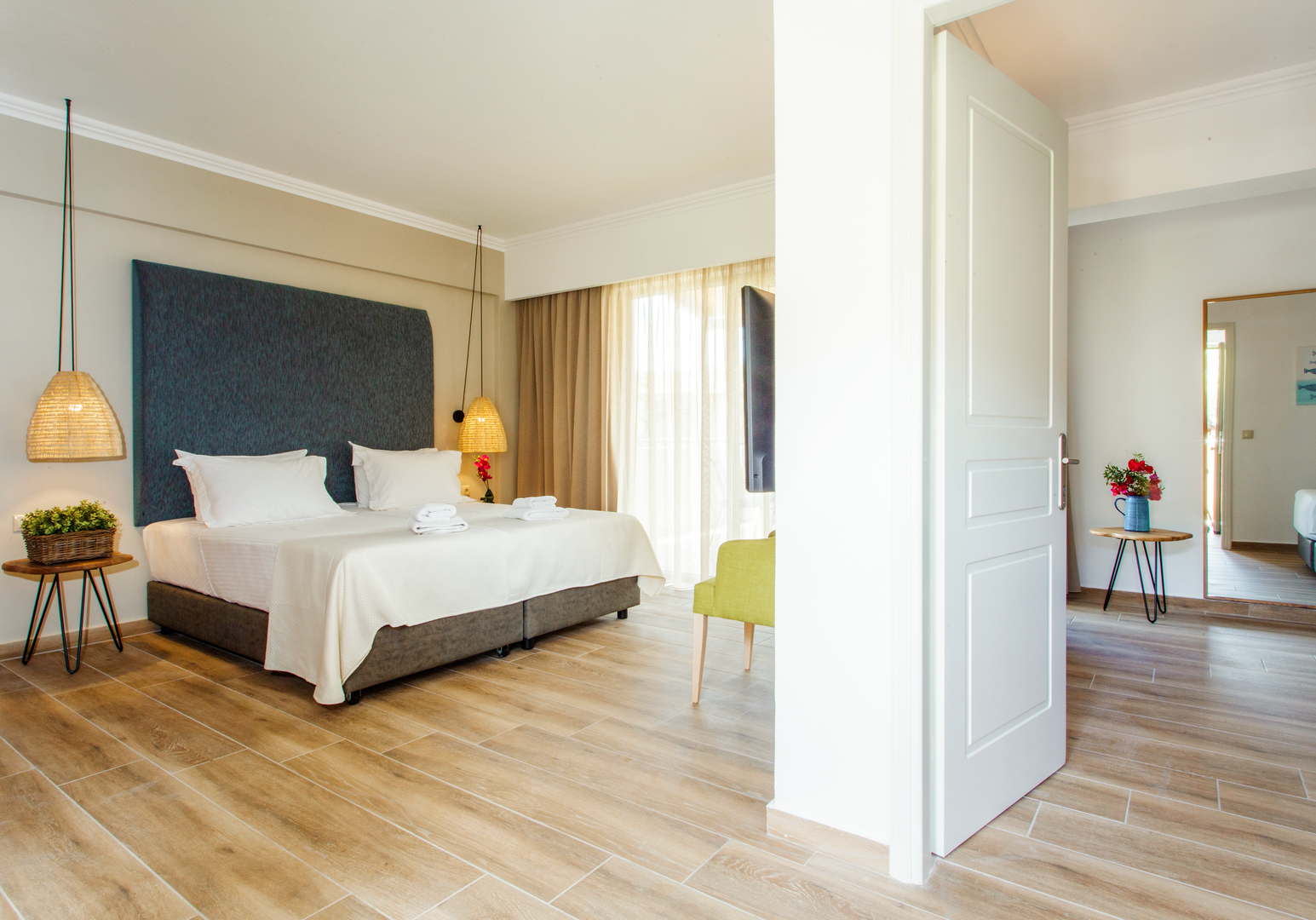 Schlafzimmer mit Doppelbett, türkisem Kopfteil und Holzboden
