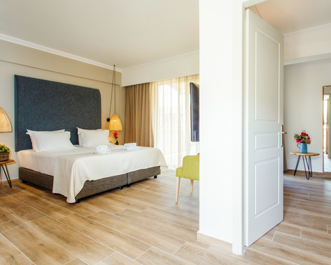 Schlafzimmer mit Doppelbett, türkisem Kopfteil und Holzboden